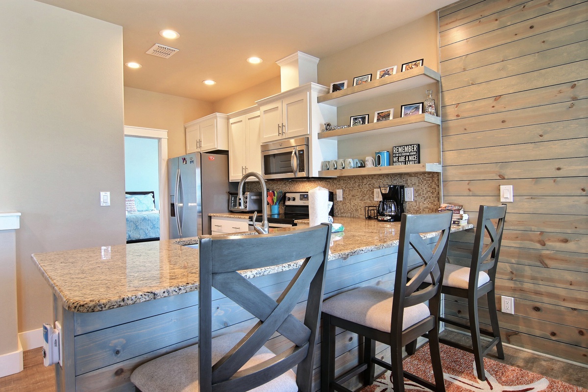 Gather around your spacious granite-topped island where morning coffee and evening conversations flow naturally in this beautifully appointed kitchen.