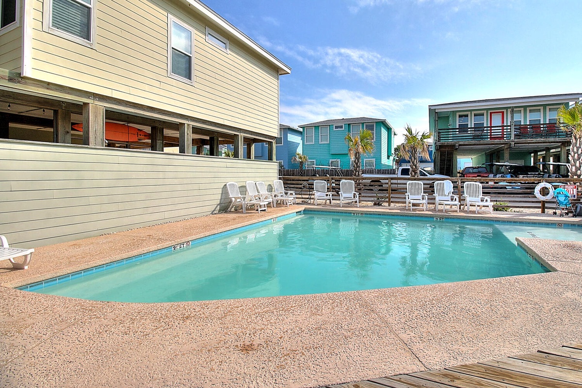 Dive into your private pool oasis surrounded by colorful beach houses and swaying palms in this coastal paradise.