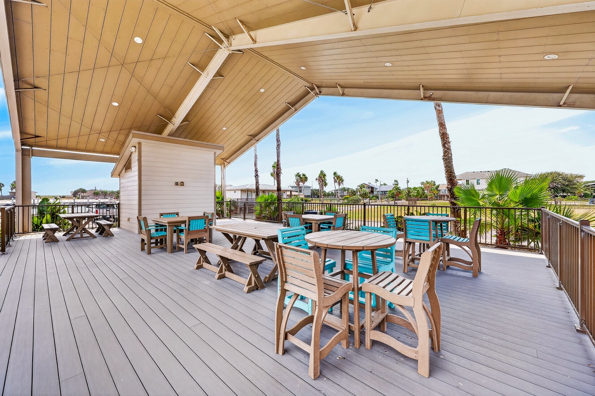 Gather with your group at this spacious covered deck, where tropical breezes meet colorful seating and palm trees sway just beyond the railing. Perfect for morning coffee or sunset dinners together.