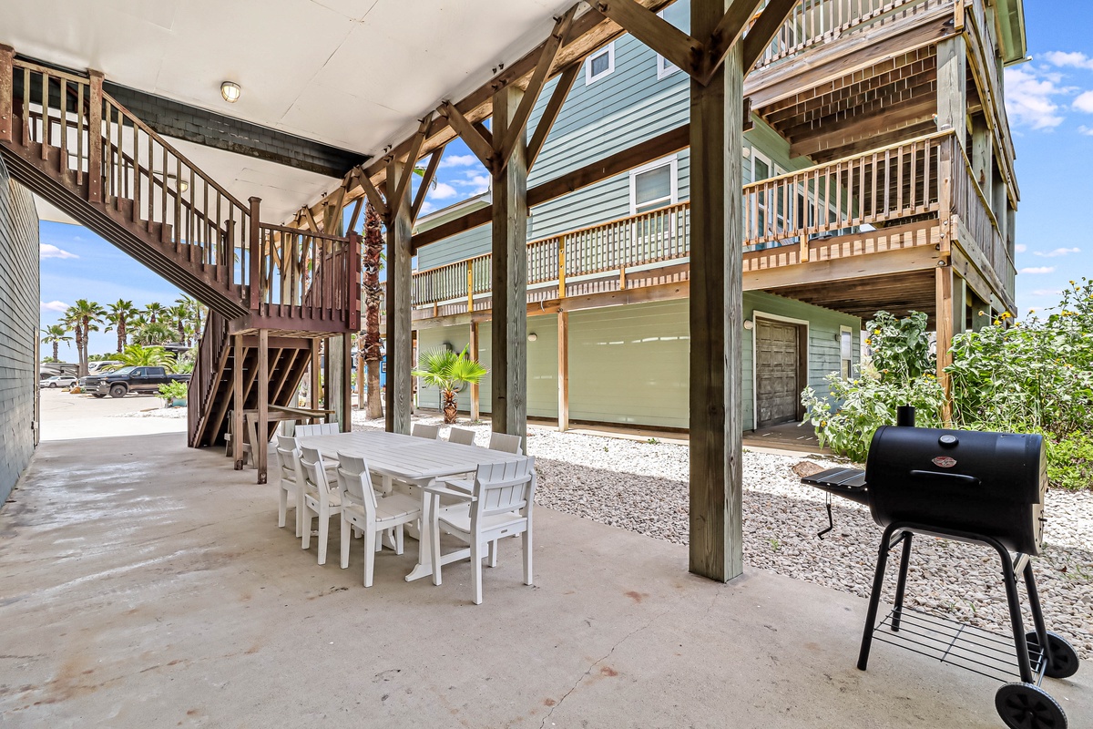 Your covered outdoor dining area awaits with seating for eight and a charcoal grill ready for seaside barbecues.