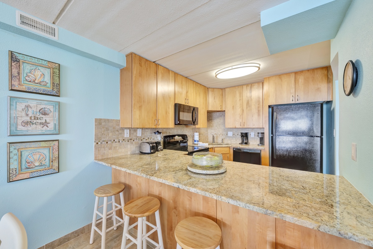 Your fully equipped kitchen features granite countertops, modern appliances, and a breakfast bar perfect for morning coffee or casual dining.