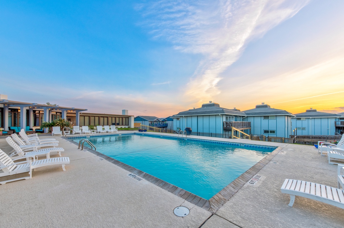 Stunning rooftop pool area with golden sunset views over the city skyline creates the perfect evening atmosphere.