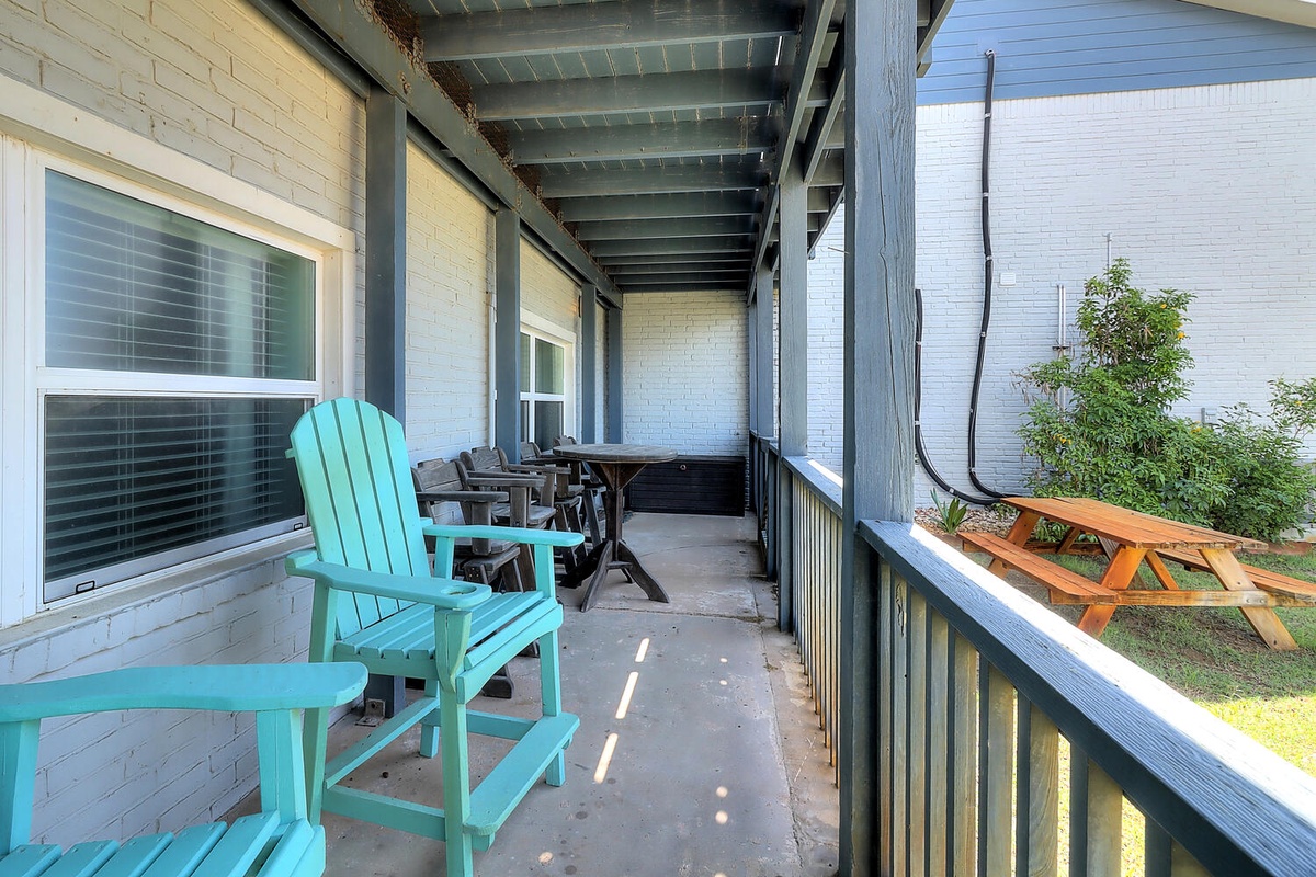 Your private covered porch offers peaceful moments with turquoise Adirondack chairs and shaded seating - perfect for morning coffee or evening relaxation.