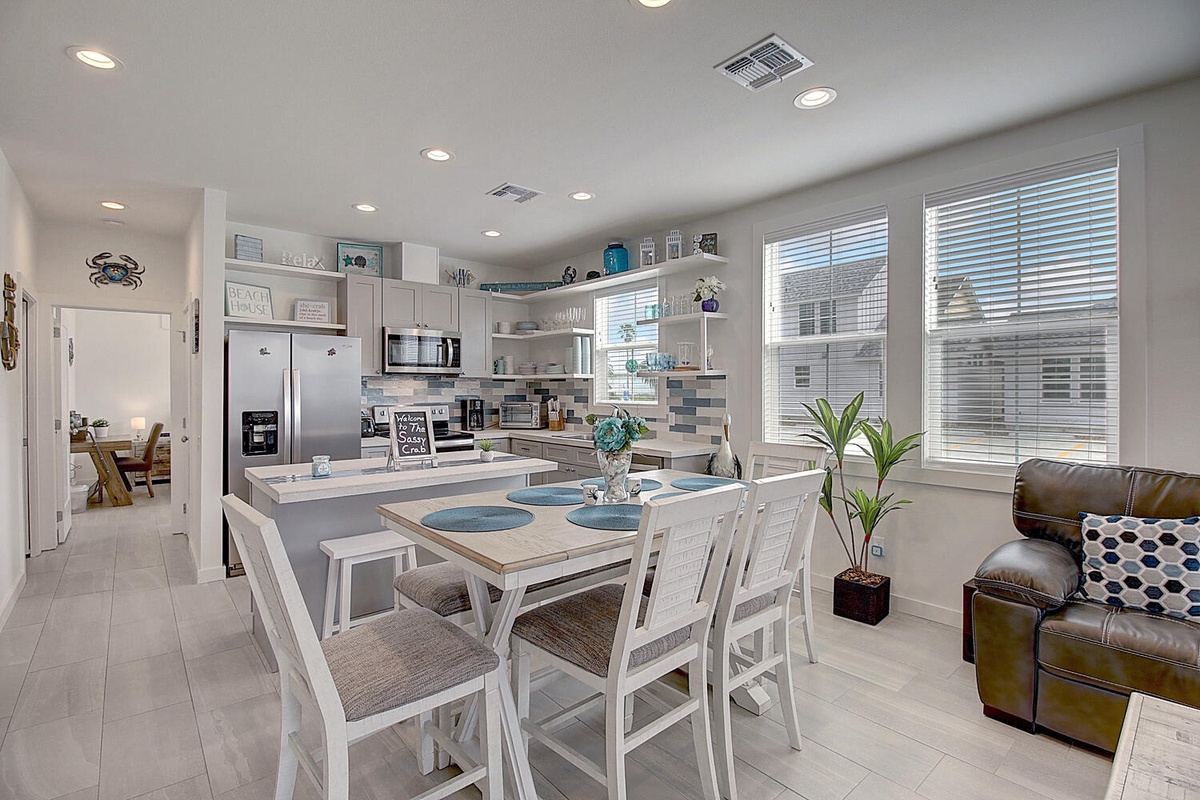 Your bright open kitchen features modern appliances and a spacious dining area where you'll gather for meals with ocean-themed touches throughout.