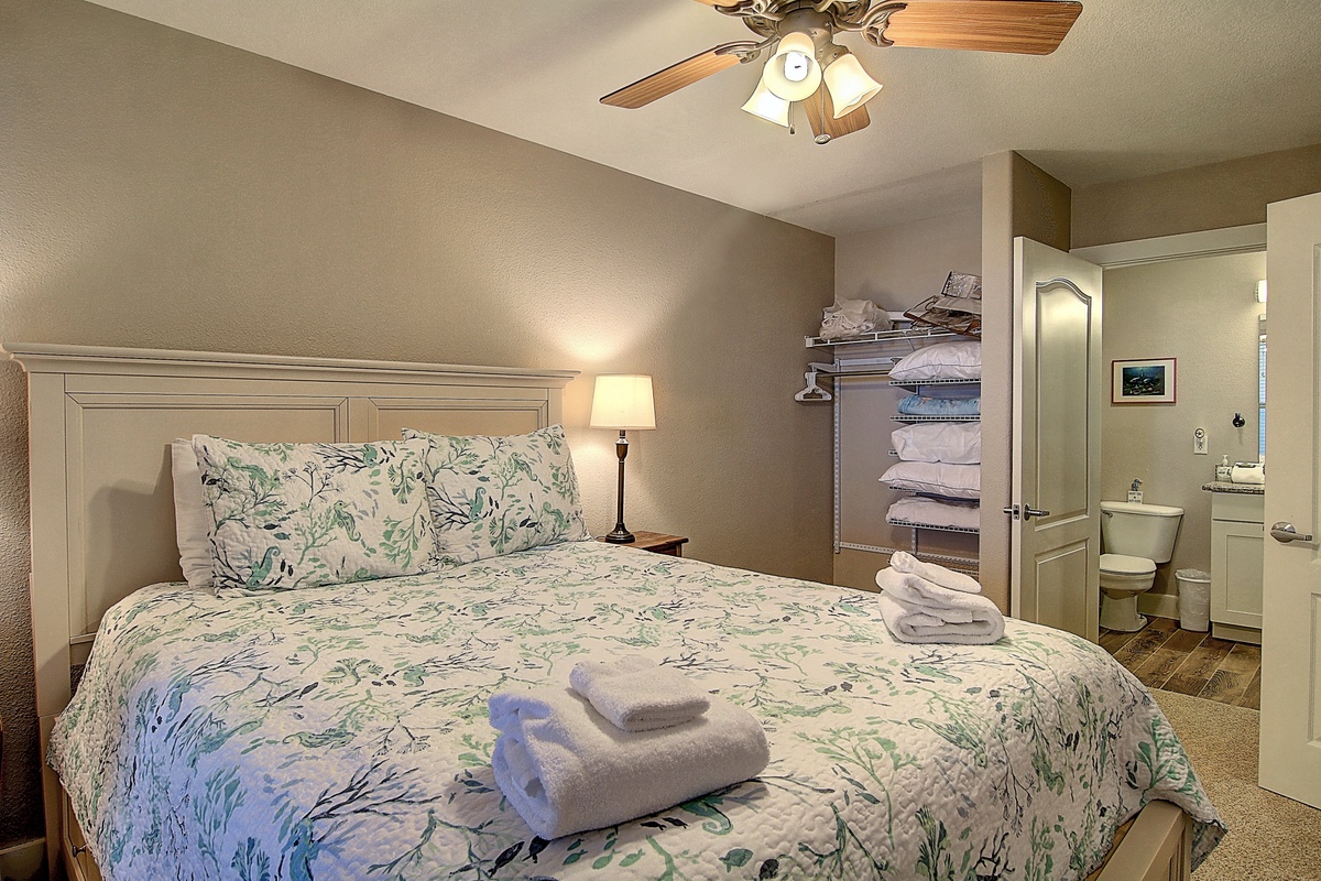 Your peaceful retreat features a comfortable bed with nature-inspired linens, while the open bathroom adds an airy feel to your space.
