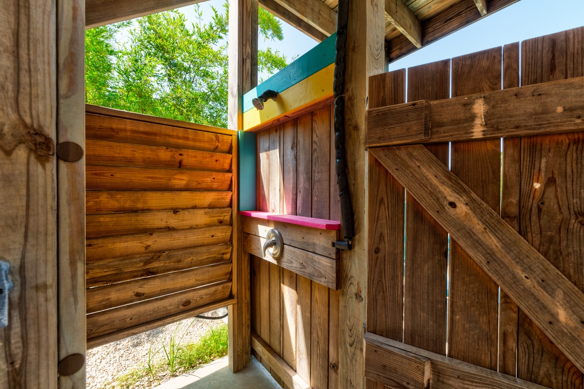 Step into your private outdoor shower oasis, where natural wood surrounds create a spa-like retreat under open sky.