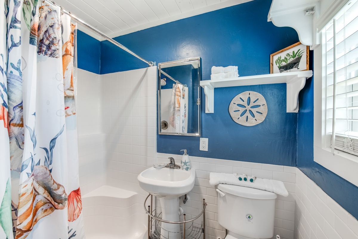 Step into your charming coastal bathroom with vibrant blue walls, nautical touches, and everything you need for a refreshing start to your day.