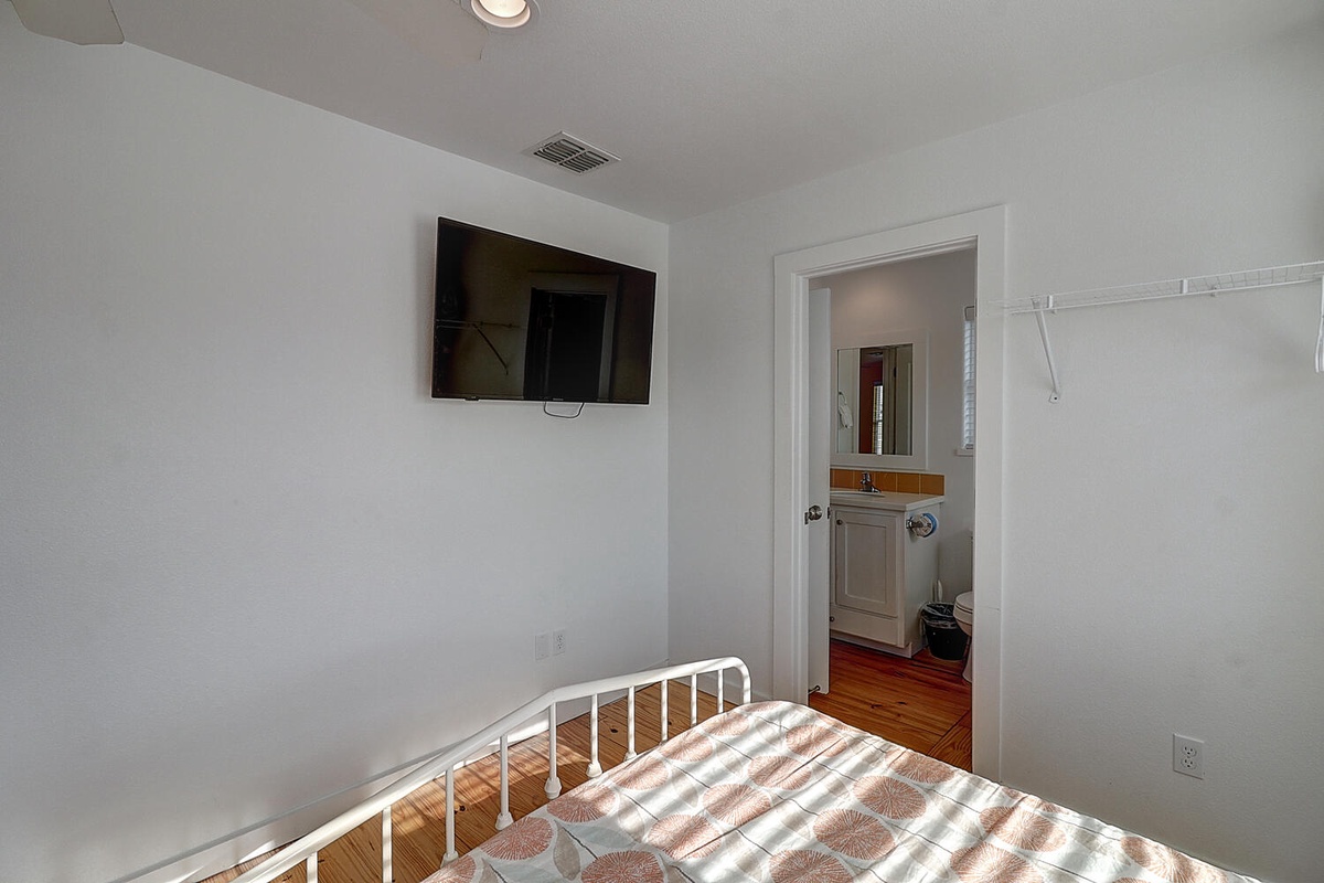 Wake up in this bright bedroom with wall-mounted TV and en-suite bathroom access for your convenience.