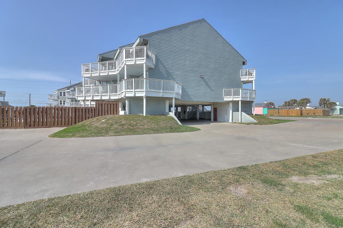 Multi-level beachside property with spacious balconies and covered parking beneath the elevated structure.
