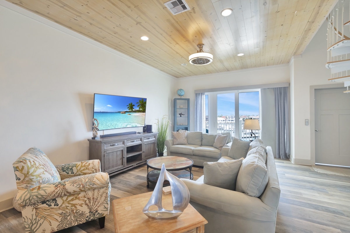 Sink into plush coastal seating beneath soaring wood ceilings while enjoying stunning city views through floor-to-ceiling windows.