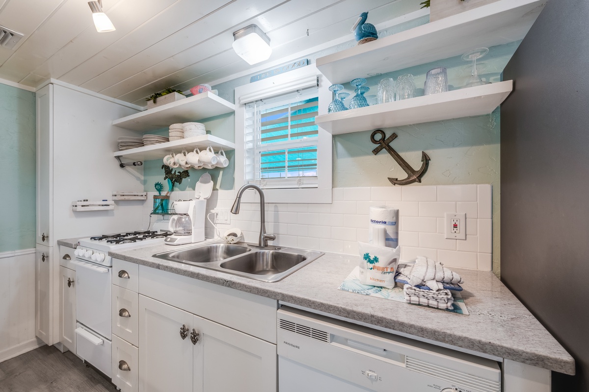 Your coastal-inspired kitchen awaits with nautical touches, full appliances, and charming open shelving for storing beach treasures.