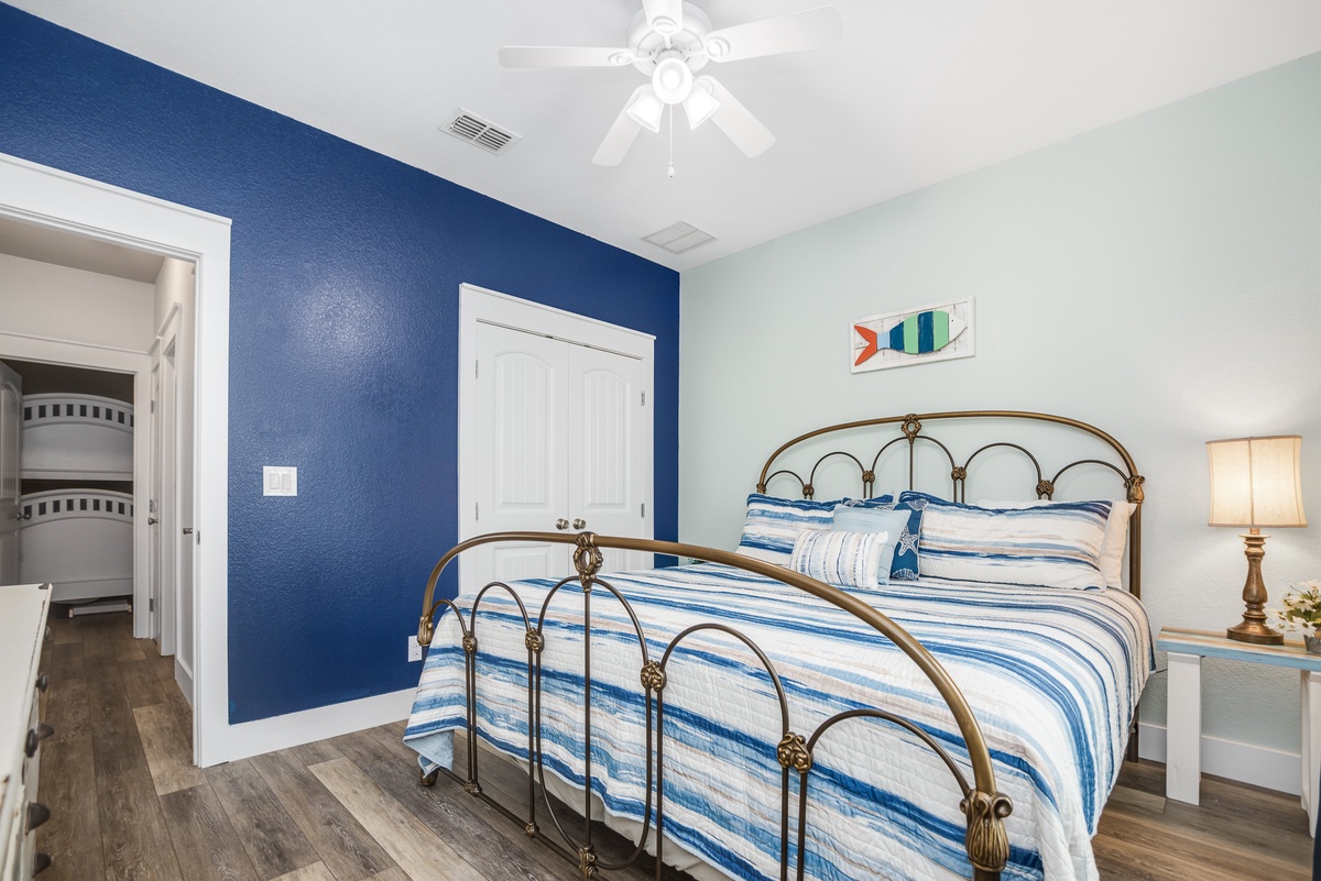 Your coastal-themed bedroom awaits with a charming brass bed, soothing blue accents, and warm lighting for ultimate relaxation.