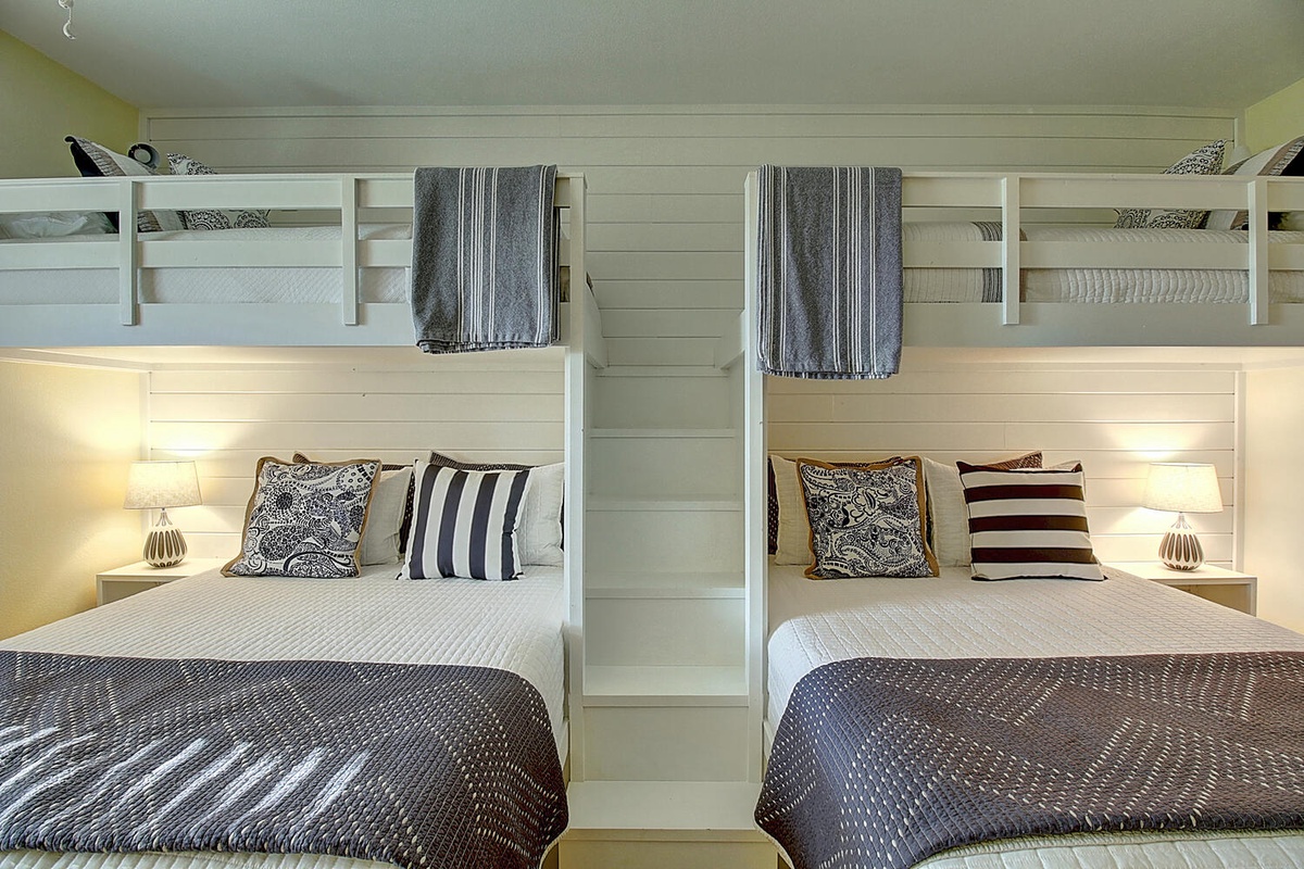 Two cozy bunk beds await with soft lighting and plush bedding, perfect for sharing memories with friends or family.