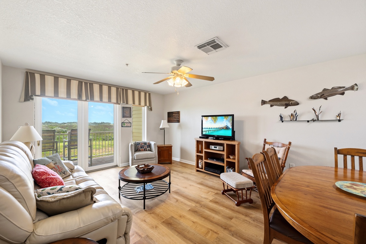 Unwind in your airy living space with cozy seating, warm wood floors, and charming coastal touches—perfect for gathering after a day of adventure.