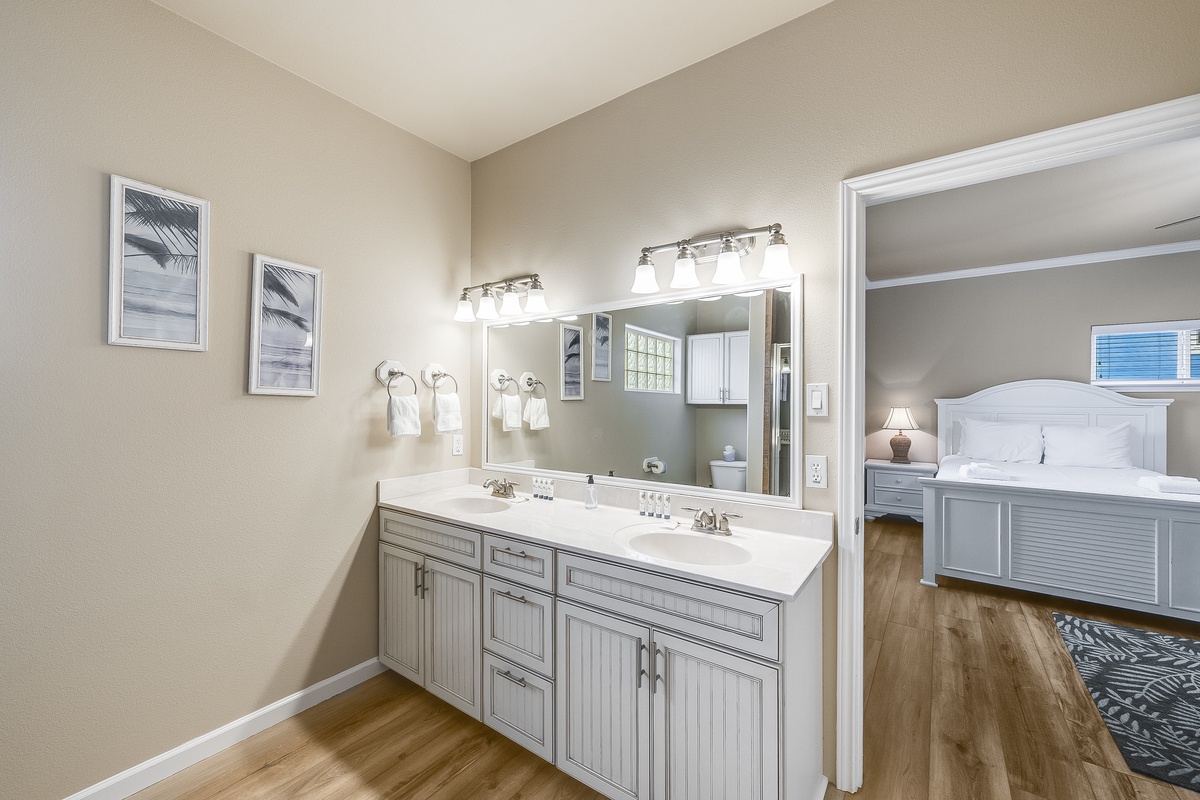 Freshen up in your spacious master bathroom with dual sinks and charming coastal artwork.