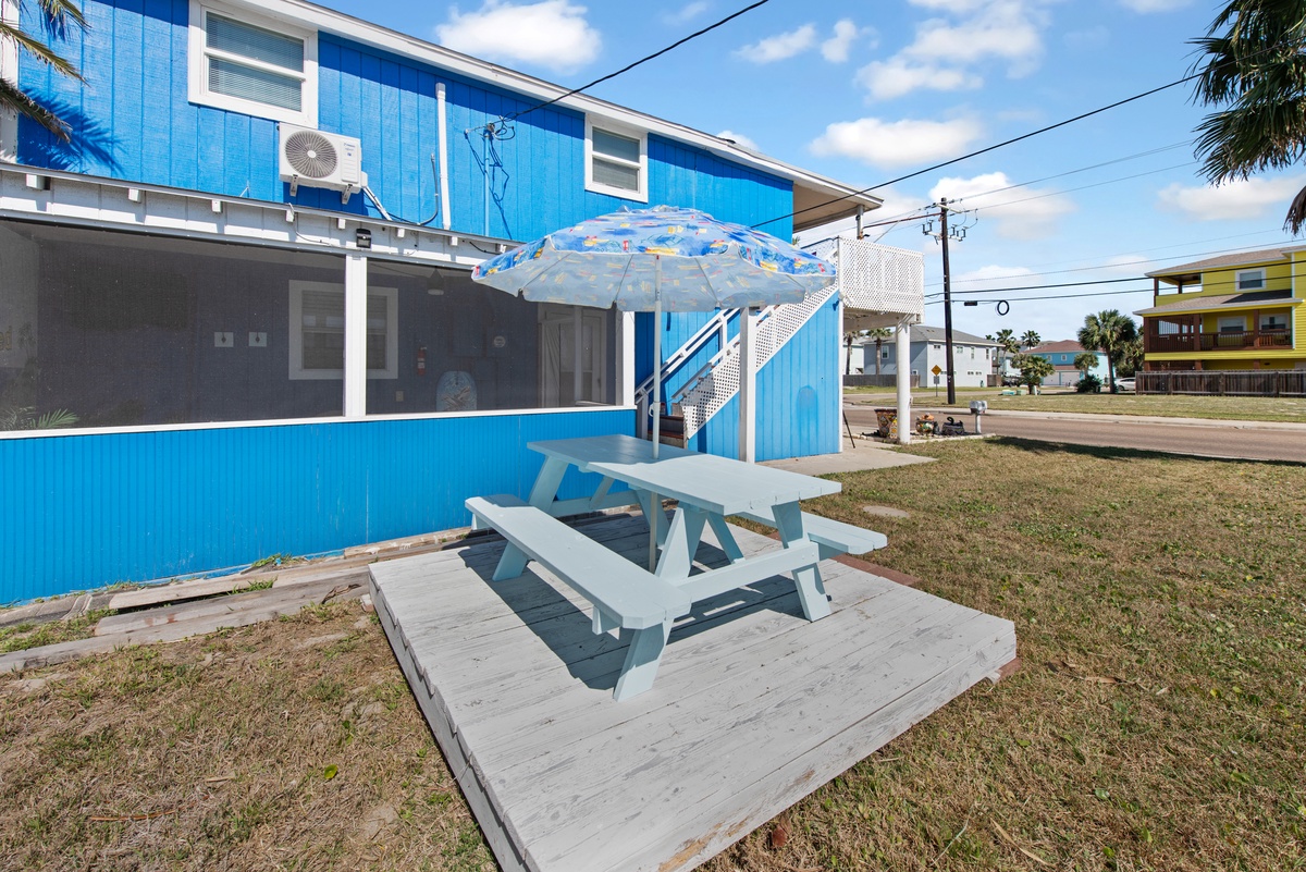 Relax at your private picnic table with umbrella shade, perfect for outdoor meals with ocean breezes nearby.