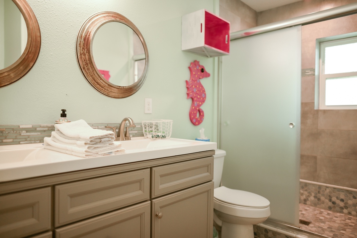 Refresh in your stylish bathroom with sparkling counters, fluffy towels, and playful seahorse decor creating a coastal retreat vibe.