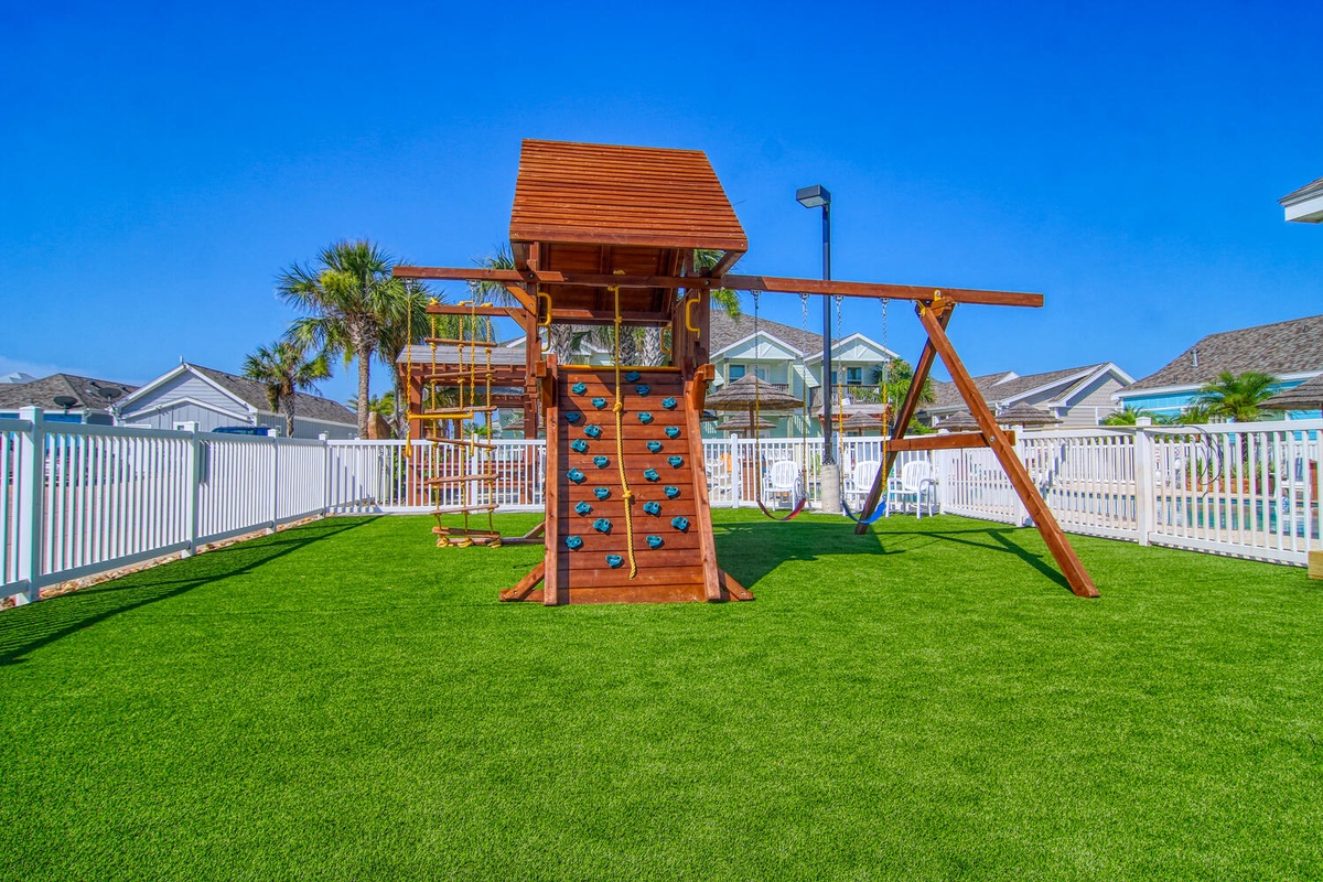 Children can enjoy the safe, fenced playground with climbing wall and swings on pristine artificial grass.