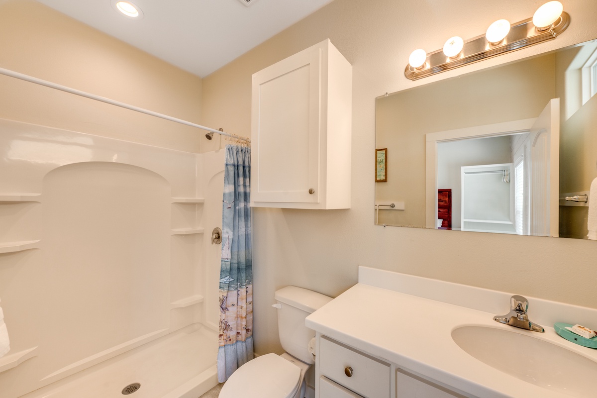 Step into your private bathroom featuring bright vanity lighting and a refreshing shower-tub combo—perfect for unwinding after exploring.