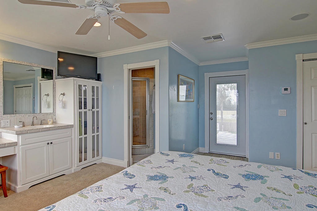 Relax in your spacious master suite with soothing blue walls, private bathroom access, and coastal-themed linens that invite peaceful nights.