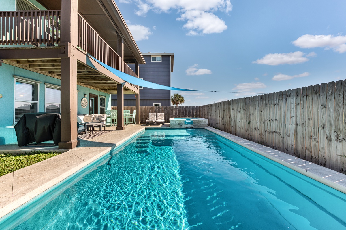 Dive into your private oasis with crystal-clear waters reflecting the open sky above your secluded backyard retreat.