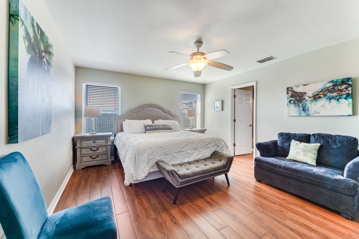 Unwind in your spacious bedroom with plush seating, elegant décor, and warm wood floors that invite barefoot mornings.