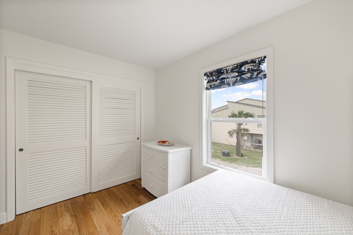 Wake up to peaceful neighborhood views from your bright bedroom, featuring crisp white linens and thoughtful storage for all your belongings.