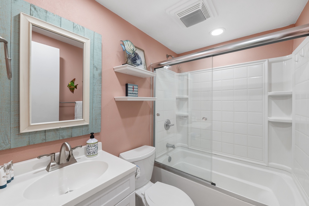 Refresh in your stylish bathroom with coral walls and spa-like amenities, featuring a soaking tub for ultimate relaxation.