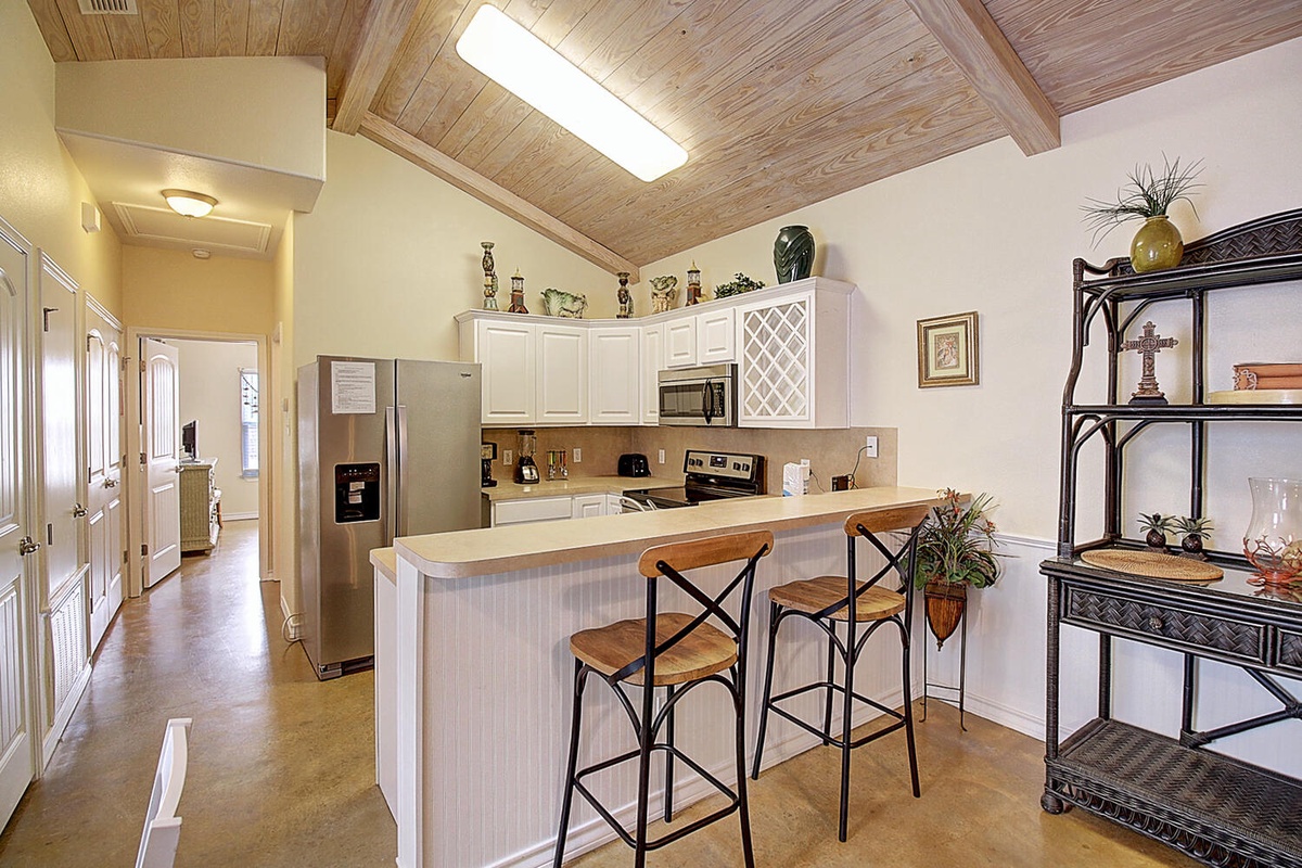 Your fully equipped kitchen features vaulted wood ceilings, stainless appliances, and a breakfast bar where you can start mornings with coffee.
