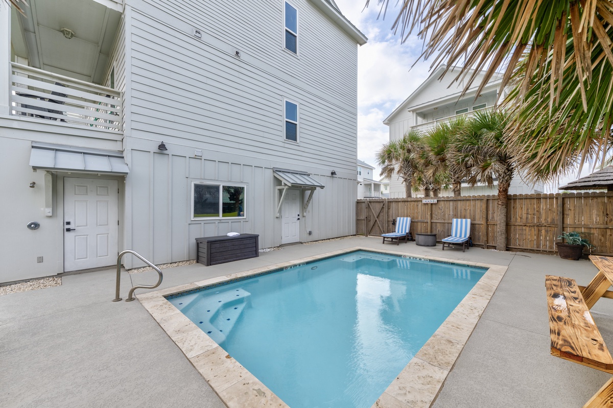 Dive into your private pool oasis surrounded by tropical palms and comfortable loungers in this secluded backyard retreat.
