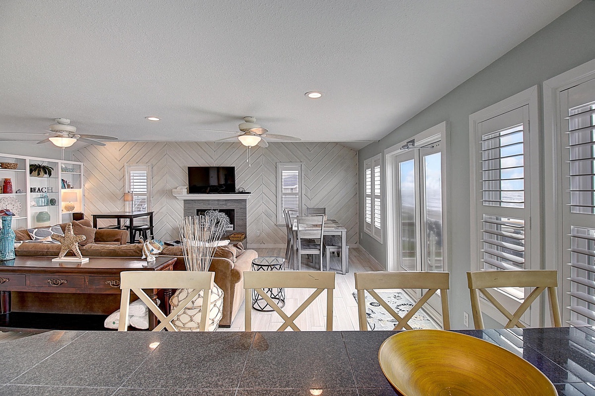 Step into your bright, airy living space with modern coastal charm, where you'll love gathering around the fireplace after beach days.