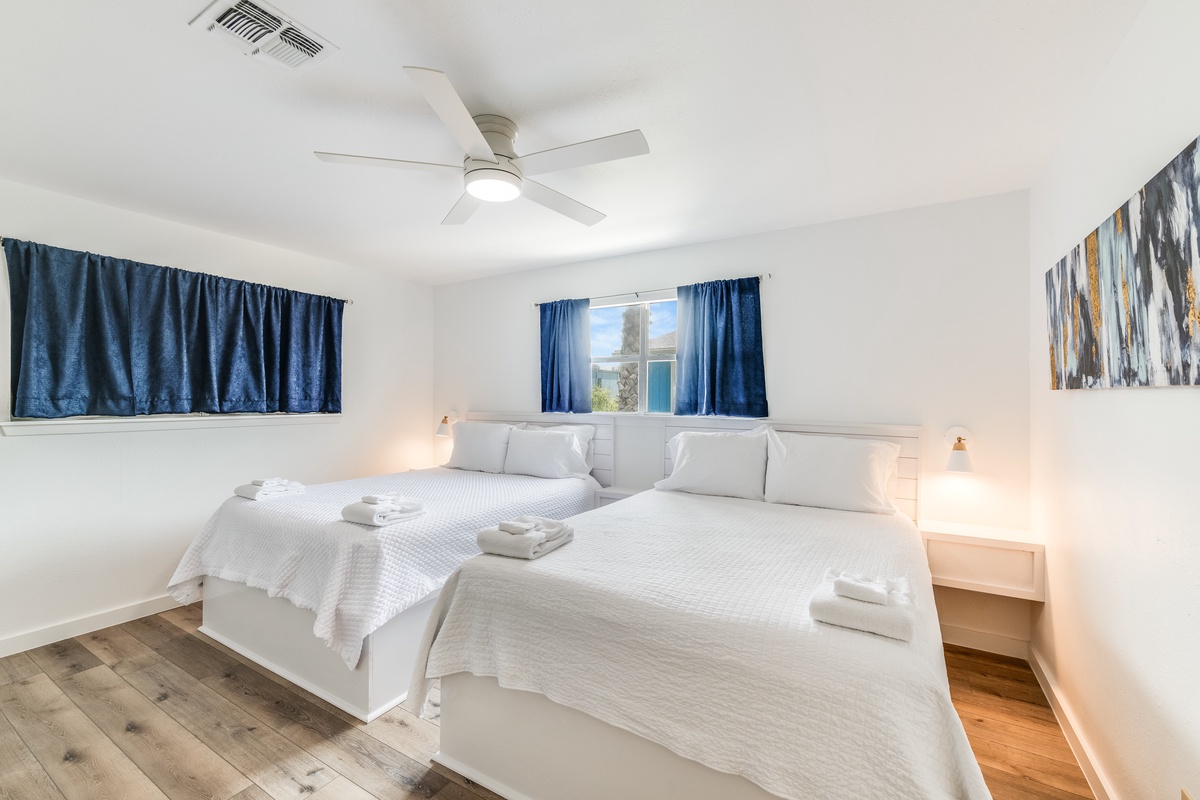 Rest peacefully in your bright, airy bedroom with twin beds, crisp linens, and cooling ceiling fan for comfortable nights.