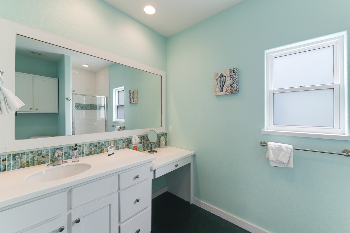 You'll love freshening up in this bright, coastal-inspired bathroom featuring sea glass accents and plenty of counter space.