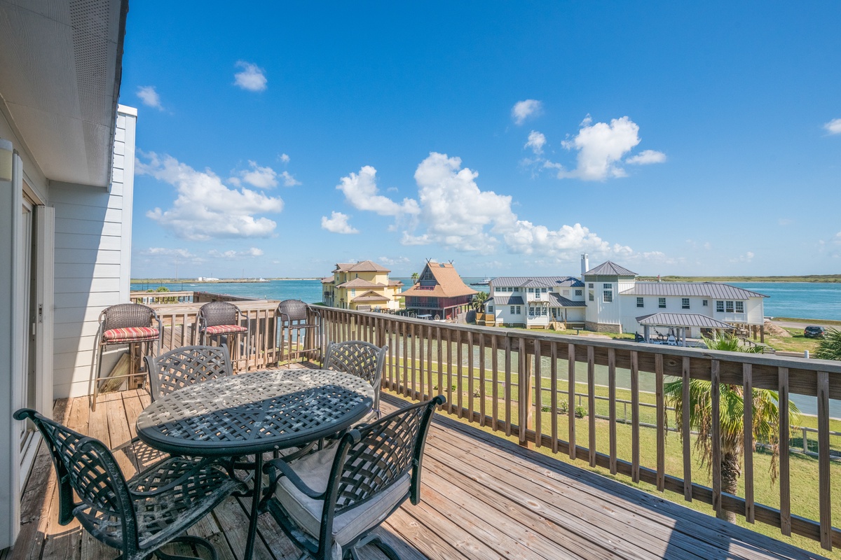 Sip morning coffee at your private table while enjoying panoramic water views and coastal charm from this peaceful balcony retreat.