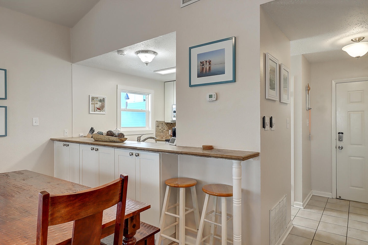Your open kitchen invites morning coffee at the breakfast bar while ocean views peek through the window.