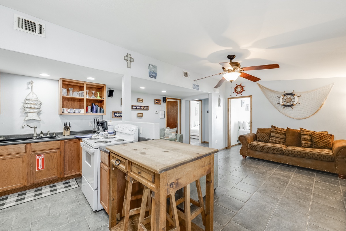 Your nautical-themed retreat features an open kitchen with island seating, perfect for preparing coastal feasts while mingling with loved ones.