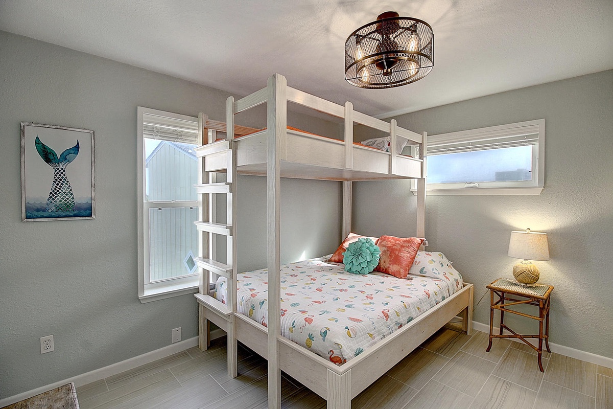 Your family will love this playful bunk bedroom, where kids can climb to their cozy top retreat while enjoying the beach-themed artwork and natural light.