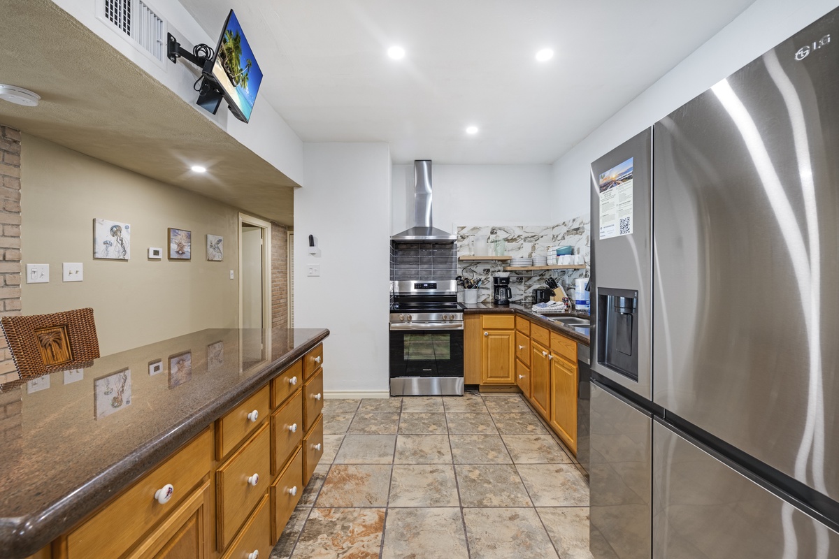 Your spacious kitchen features modern stainless steel appliances, granite countertops, and warm wooden cabinetry—perfect for preparing memorable vacation meals together.