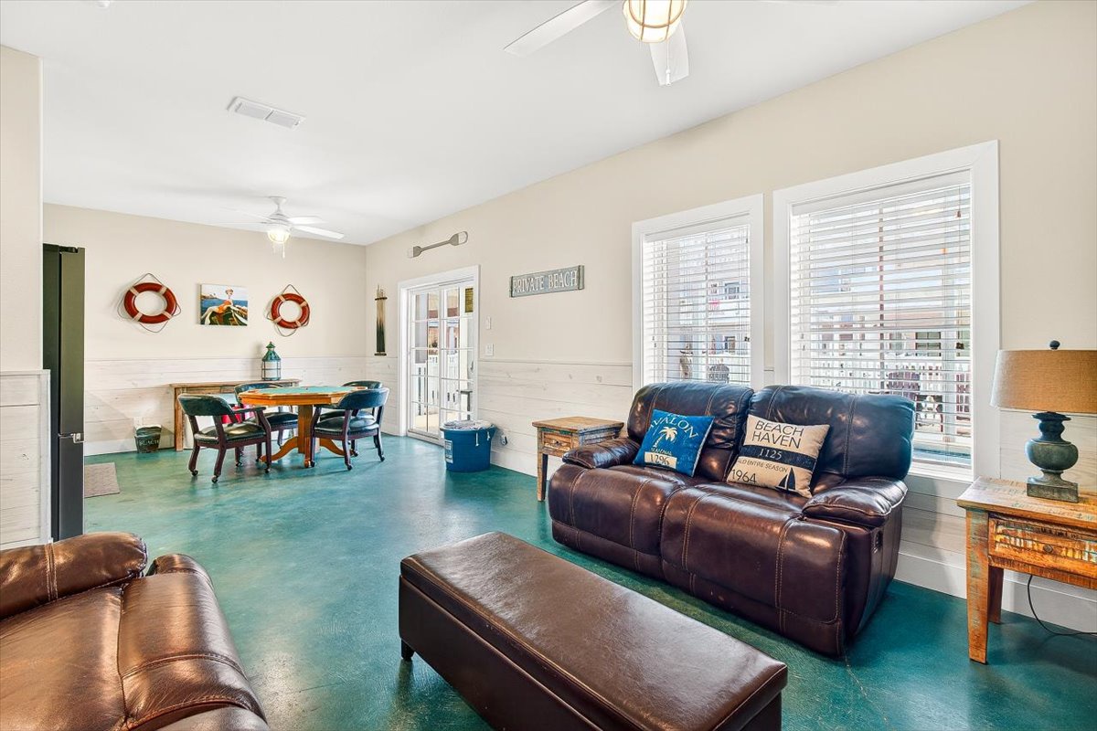 Sink into plush leather seating in your coastal-themed living space, where nautical touches and turquoise floors create the perfect beach house atmosphere.