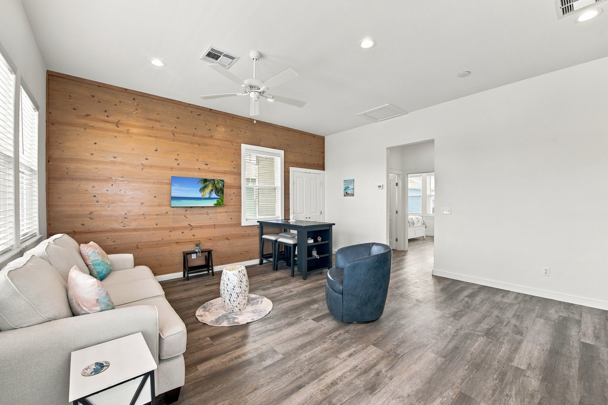 Sink into the plush seating and unwind in your spacious living area, where warm wood tones and coastal breezes create the perfect retreat after a day of adventure.