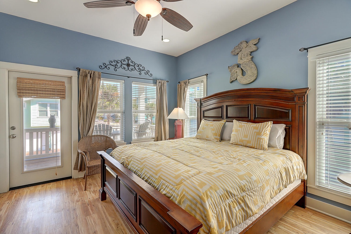 Drift off in your serene bedroom featuring a plush bed, ceiling fan, and private balcony access for morning coffee moments.