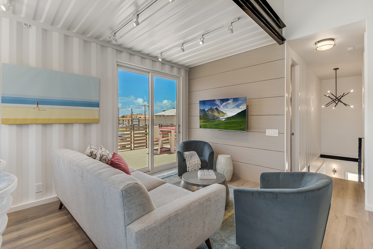 Relax in your bright living room with comfy seating, modern TV, and sliding doors opening to your private outdoor space.