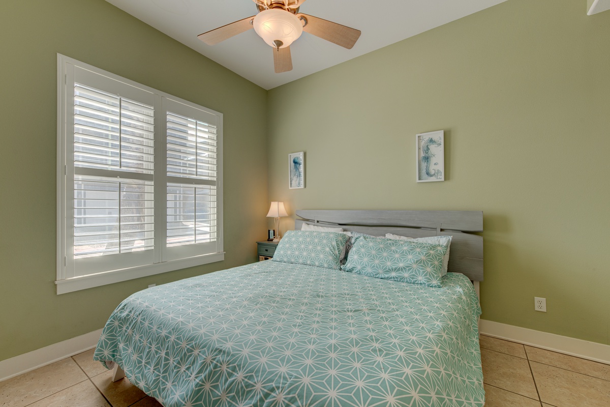 Sink into your serene retreat with calming sage walls, crisp linens, and gentle ceiling fan breezes keeping you cool.