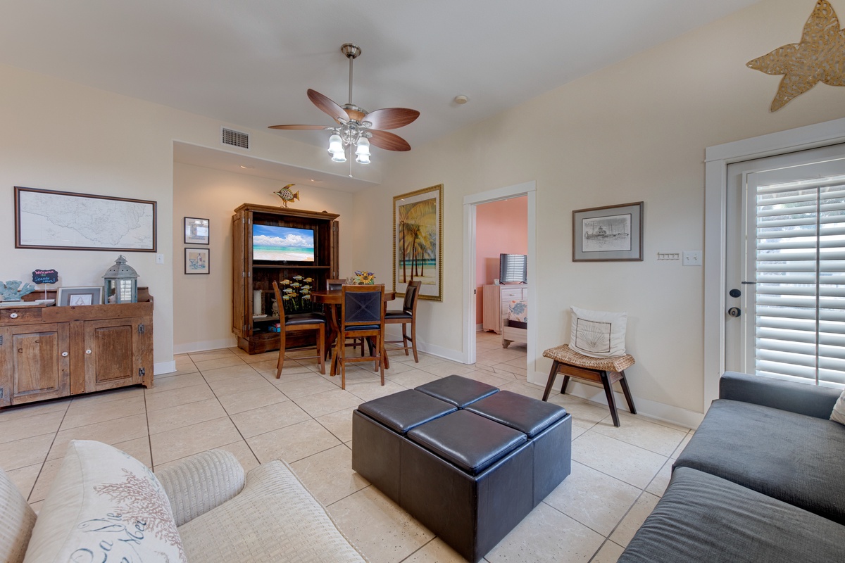 Relax in your bright living space with coastal charm, featuring comfortable seating and entertainment center for perfect vacation evenings.