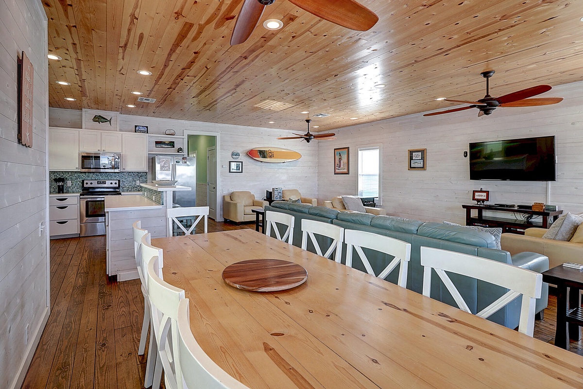Gather around your rustic dining table where warm wood meets coastal charm, then sink into the plush living area for movie nights.