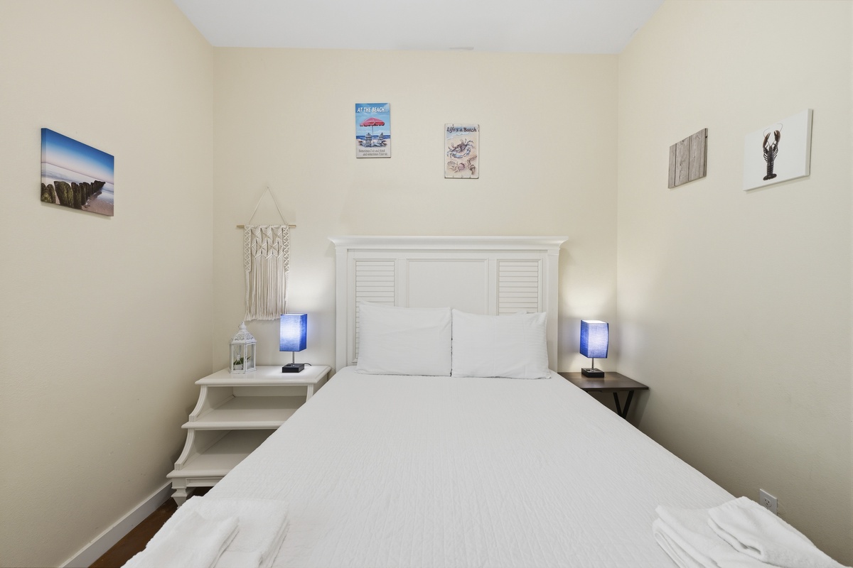 Relax in your serene coastal retreat, where crisp white linens and charming nautical touches create a peaceful haven for restful nights.