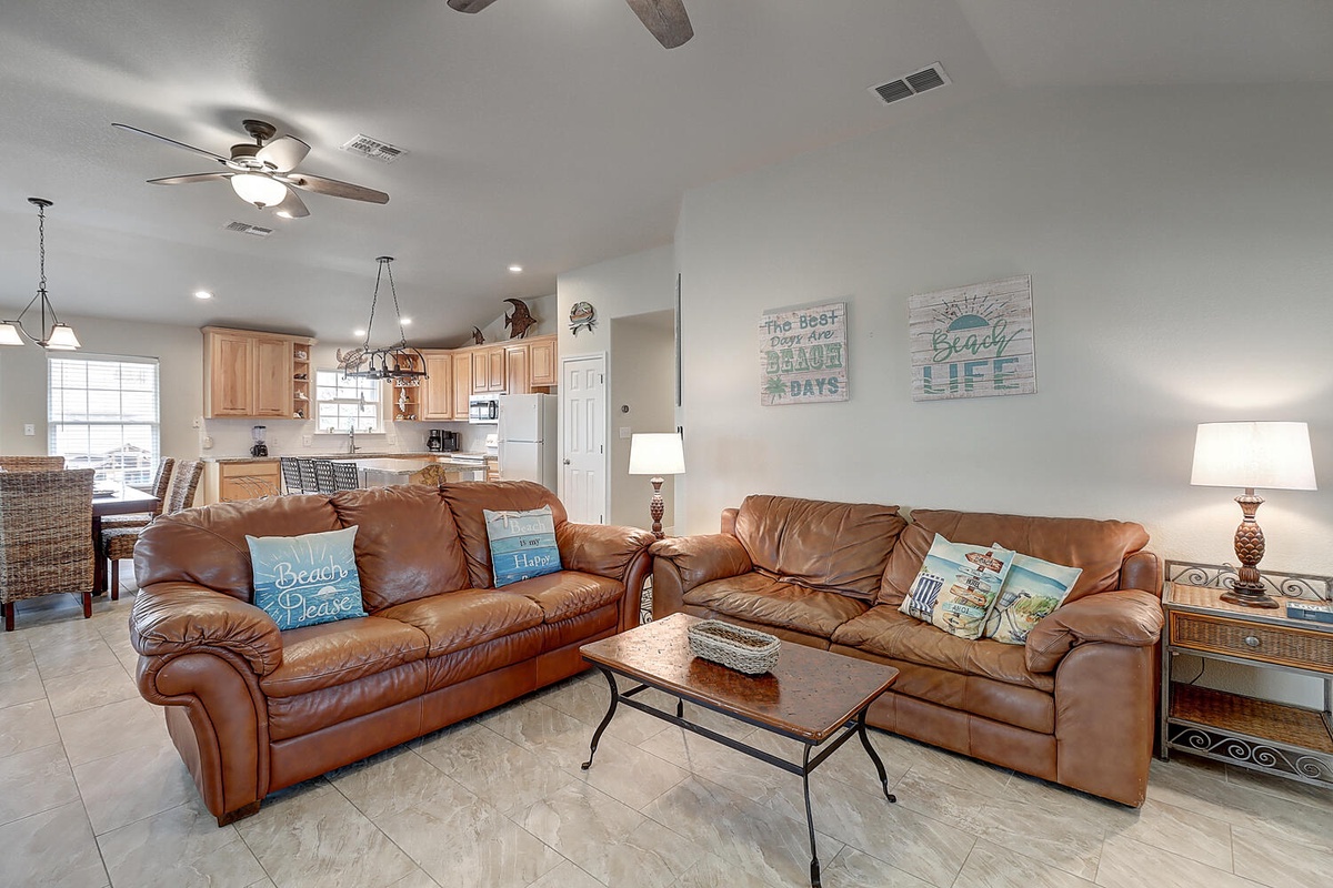 Sink into plush leather sofas where coastal charm meets comfort, with your fully equipped kitchen just steps away for easy vacation dining.