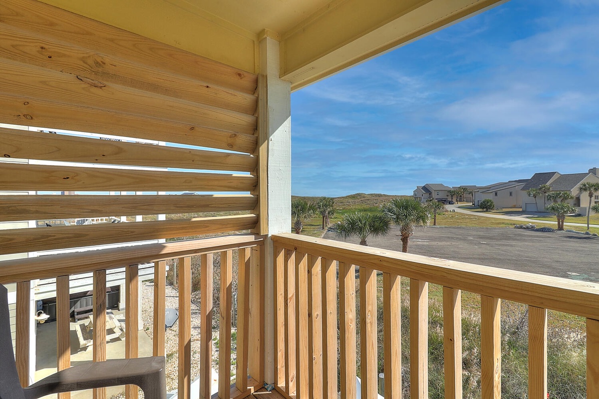 Relax on your private balcony with neighborhood views and coastal breezes under the pergola's natural shade.