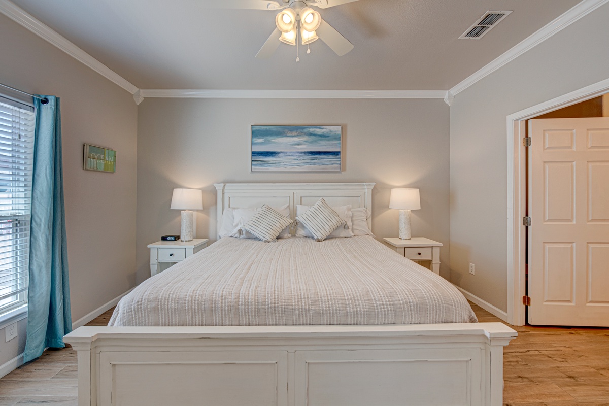 Slip into crisp white linens beneath calming ocean art, where bedside lamps cast a warm glow for your perfect night's rest.
