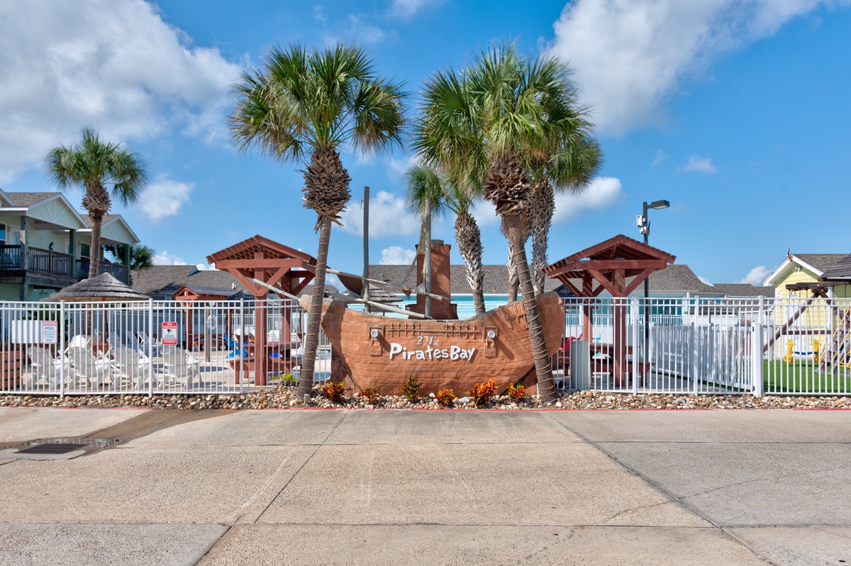 Pirates Bay resort entrance with distinctive pirate ship sign and tropical palm trees welcoming guests to this themed coastal property.